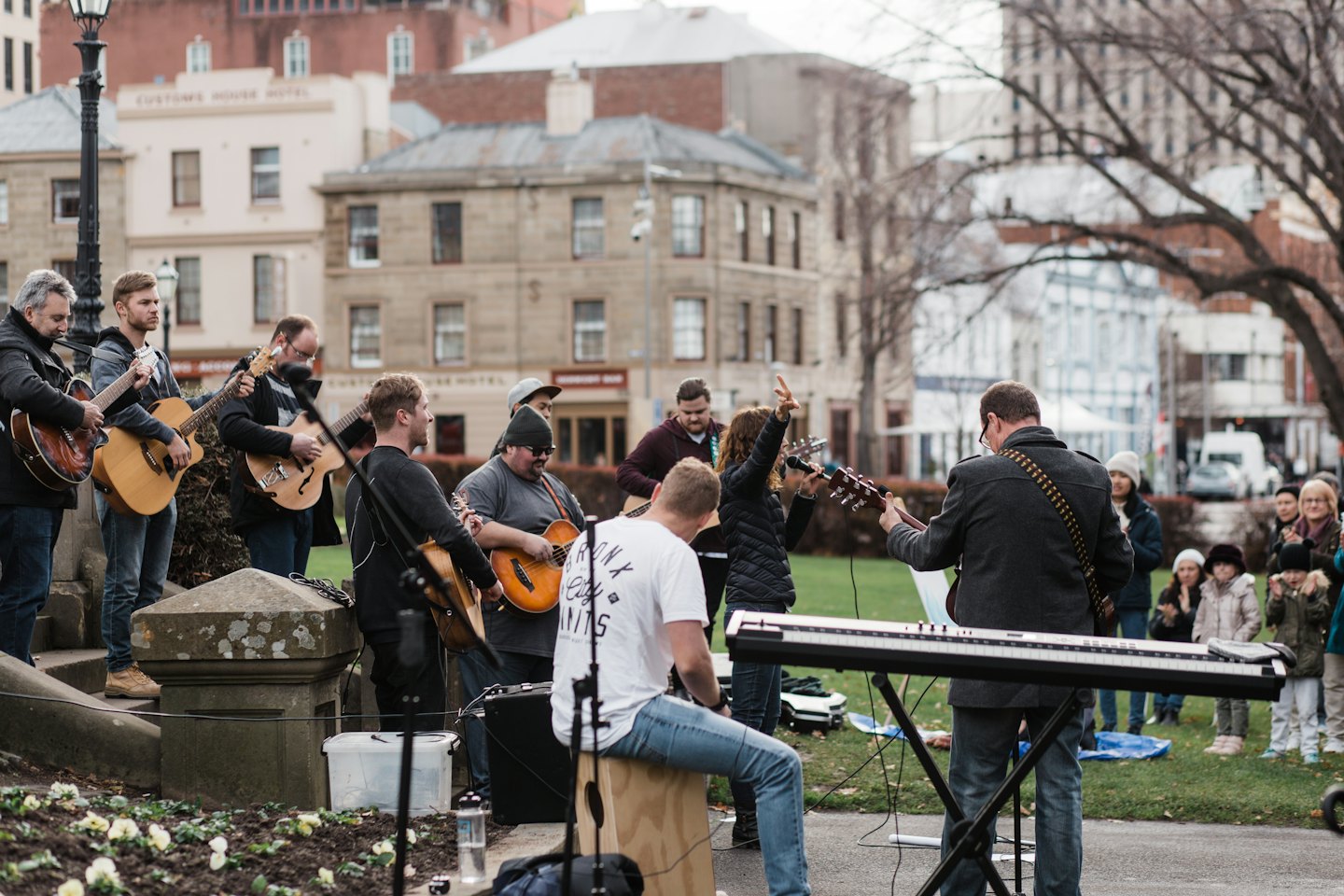 Outdoor band plays music in a park with an audience.