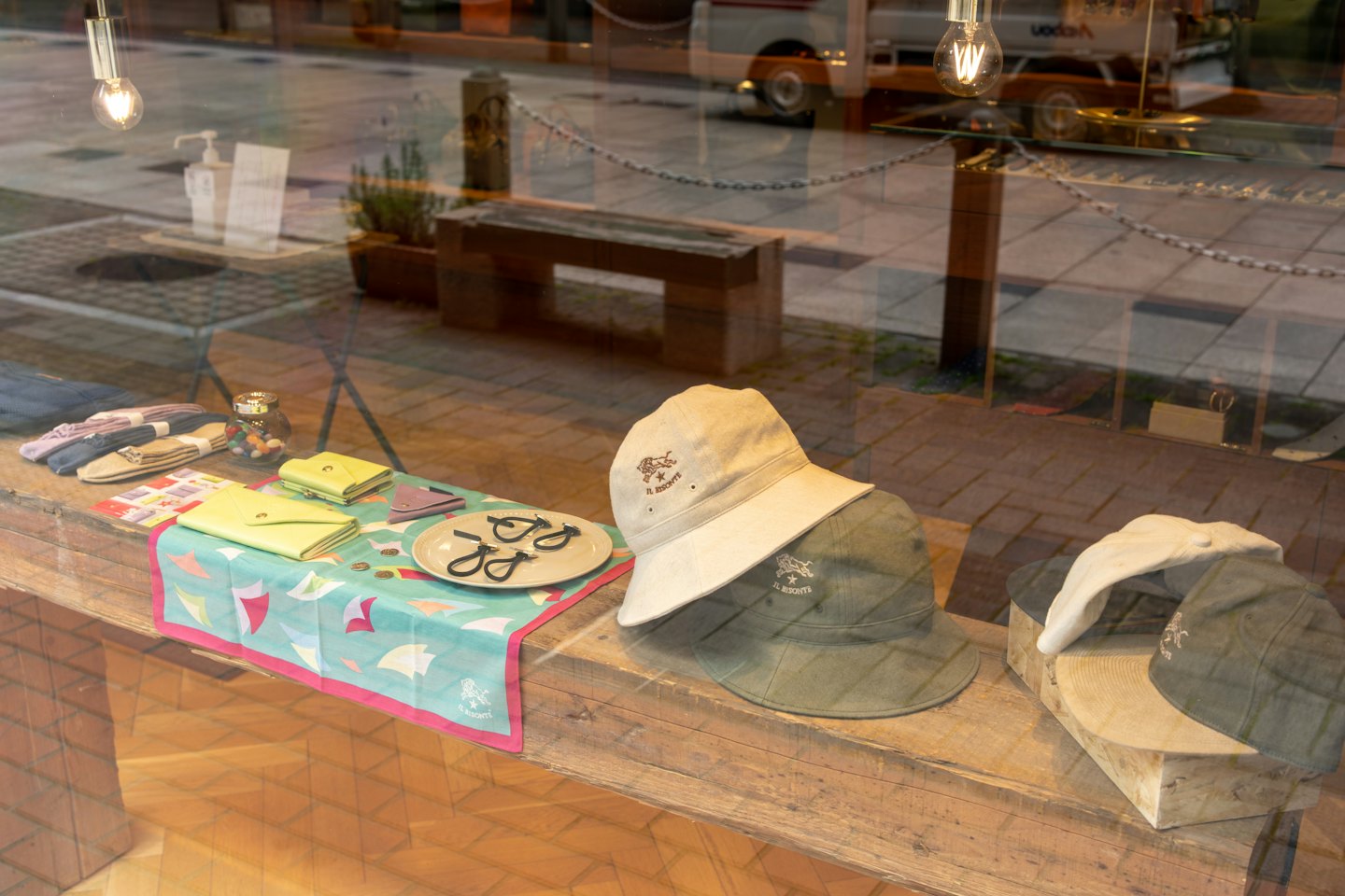 Assorted hats, wallets, and shoes displayed on a rustic shelf.